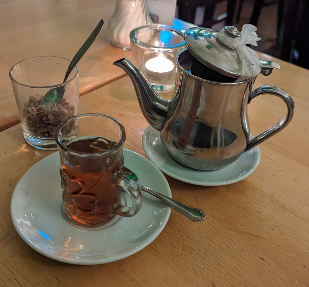 Tee im Kännchen, dazu Kandis-Zucker und ein Gläschen voll mit Tee im Shady Leipzig Tee im Kännchen, dazu Kandis-Zucker und ein Gläschen voll mit Tee im Shady Leipzig